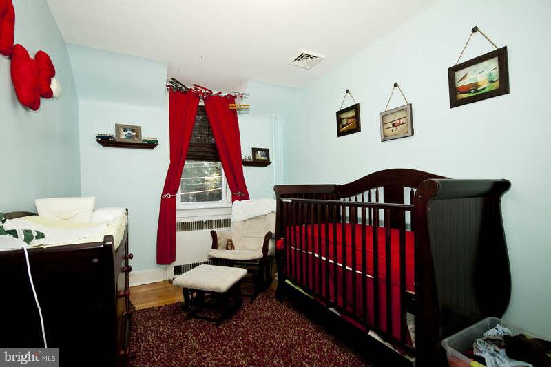 416 Hopkins Road Baltimore, MD 21212 - Photo 18 of 30 a bedroom with a bed and wooden floor