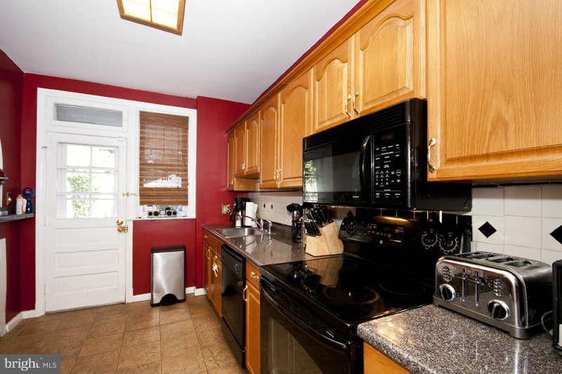 416 Hopkins Road Baltimore, MD 21212 - Photo 9 of 30 a kitchen with a sink a stove and a wooden cabinets