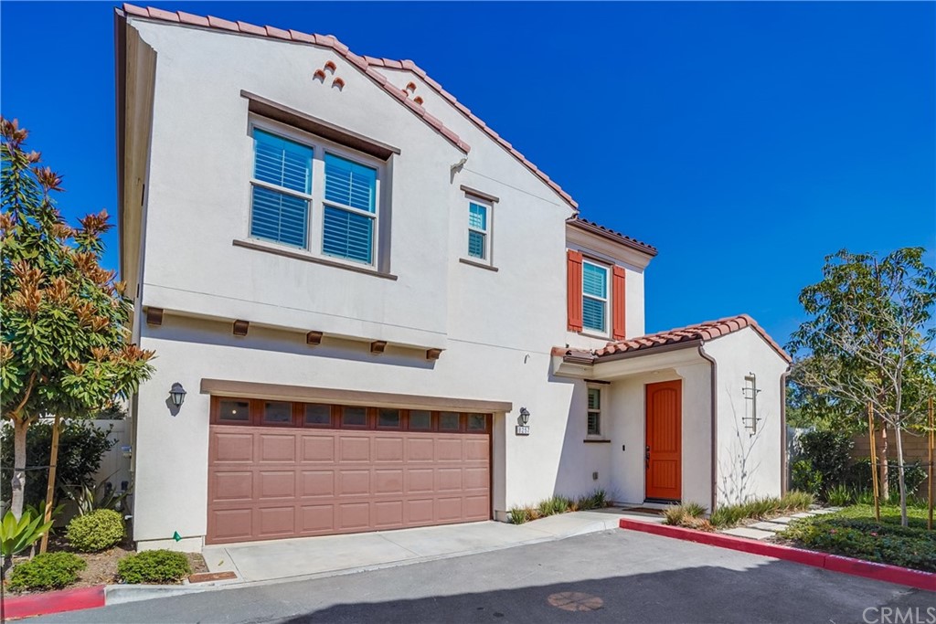 a view of a white house with a yard and potted plants
