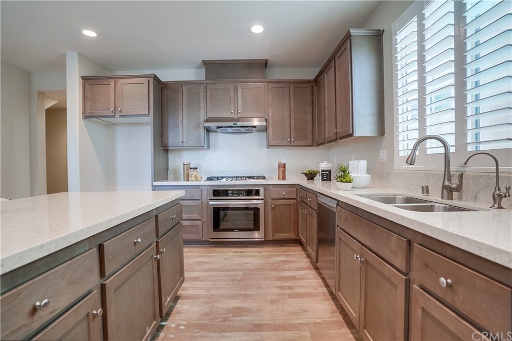 8257 Bella Rosa Drive Rosemead, CA 91770 - Photo 14 of 32 a kitchen with kitchen island granite countertop a sink a counter space appliances and cabinets