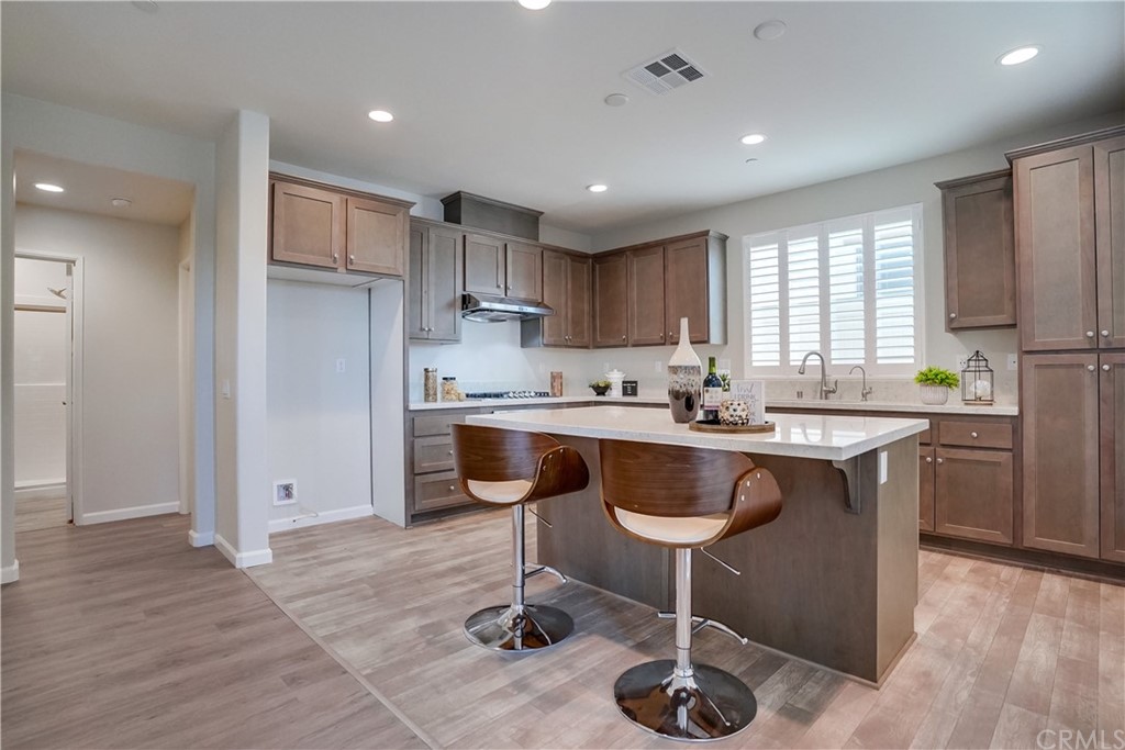 8257 Bella Rosa Drive Rosemead, CA 91770 - Photo 10 of 32 a kitchen with kitchen island granite countertop wooden floors and a refrigerator