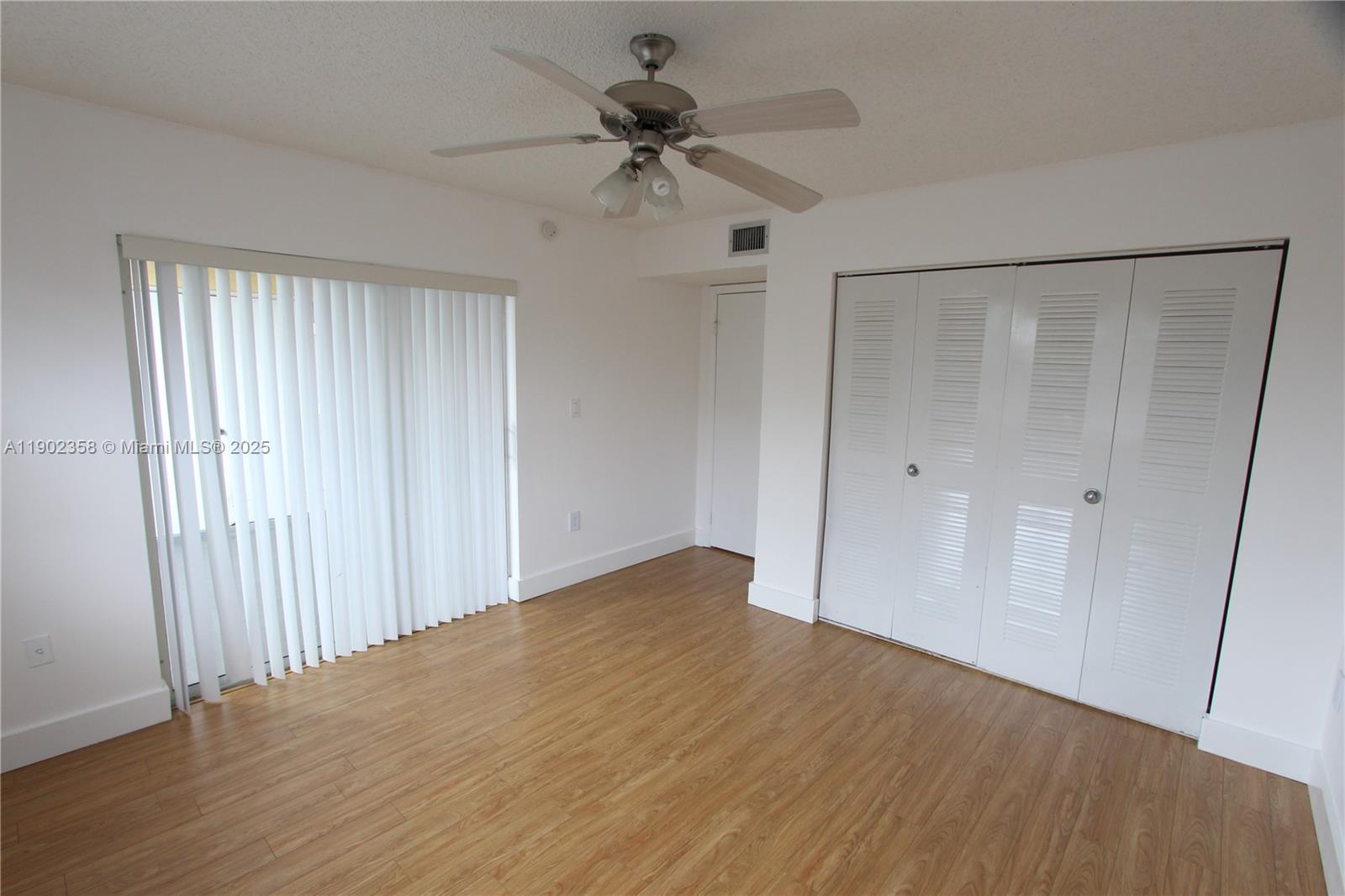 8540 Southwest 212th Street, Unit 203 Cutler Bay, FL 33189 - Photo 15 of 29 wooden floor in an empty room with a window