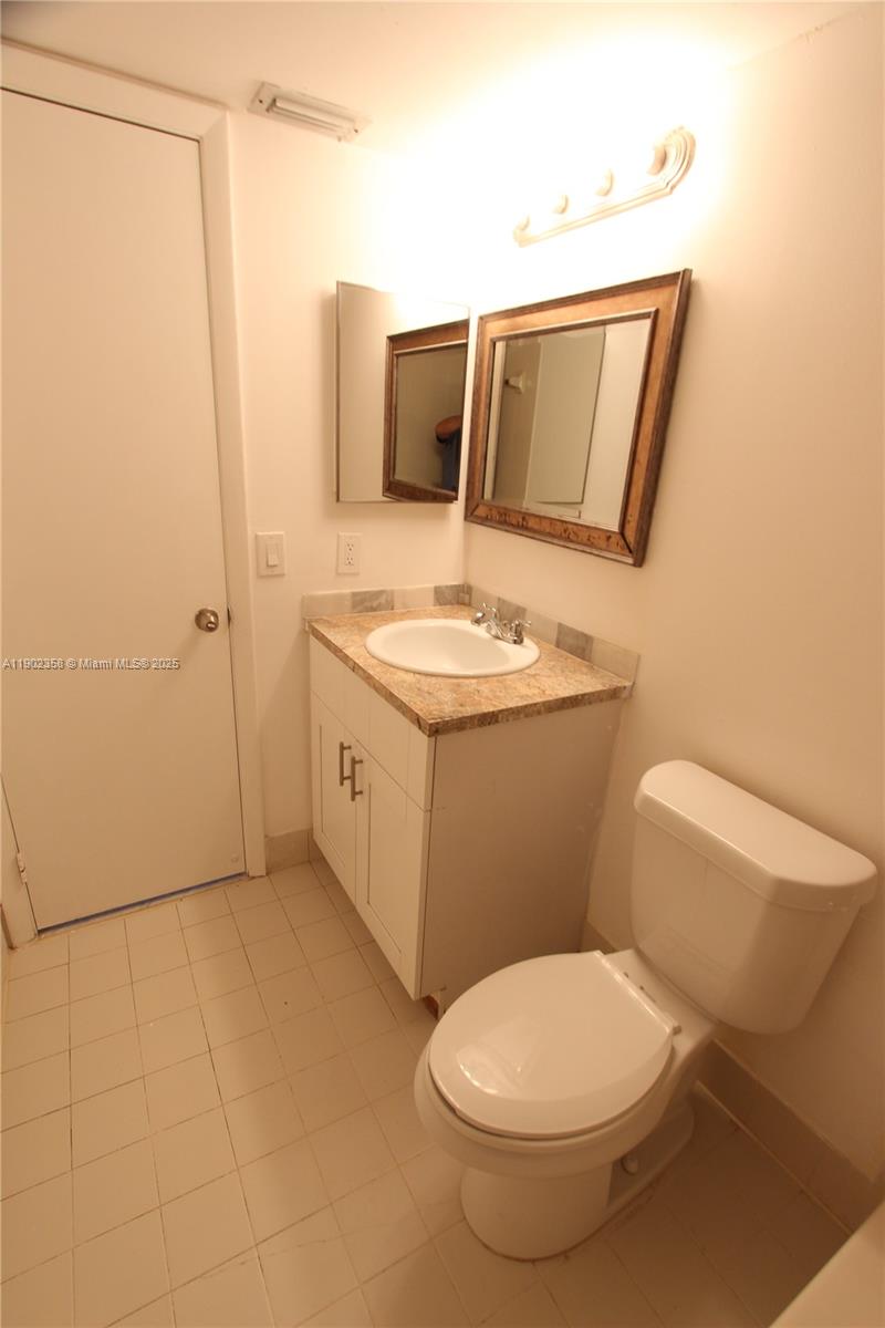 8540 Southwest 212th Street, Unit 203 Cutler Bay, FL 33189 - Photo 26 of 29 a bathroom with a toilet sink and mirror
