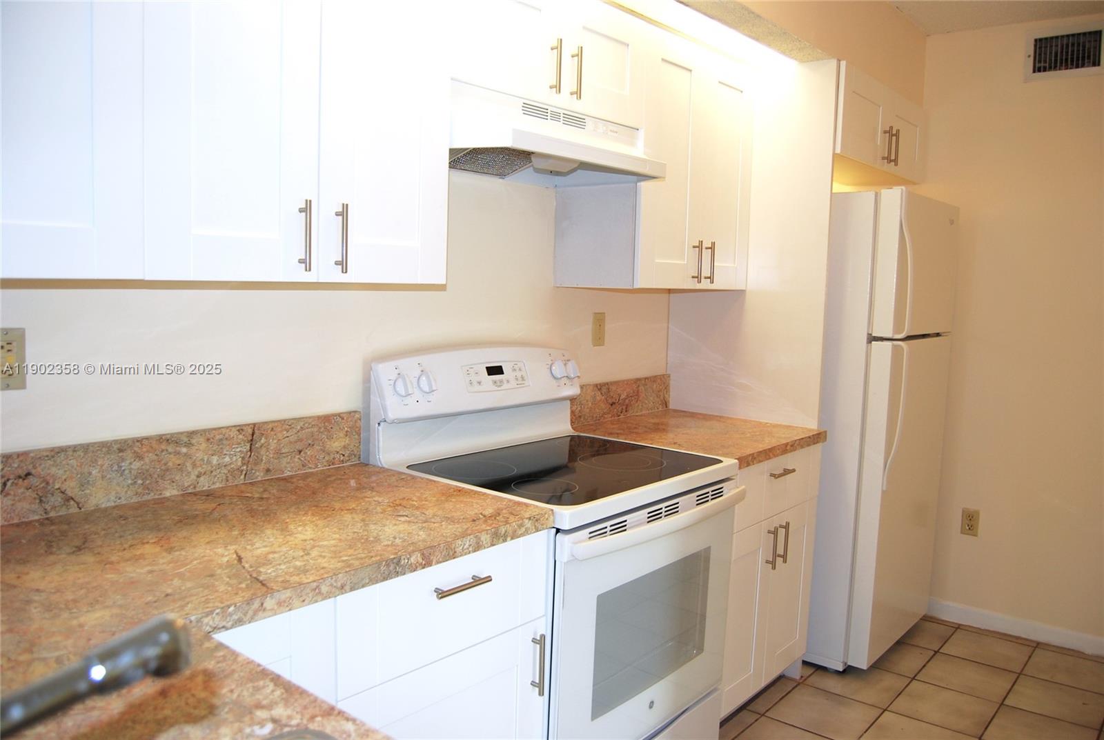 8540 Southwest 212th Street, Unit 203 Cutler Bay, FL 33189 - Photo 5 of 29 a kitchen that has a sink and a stove
