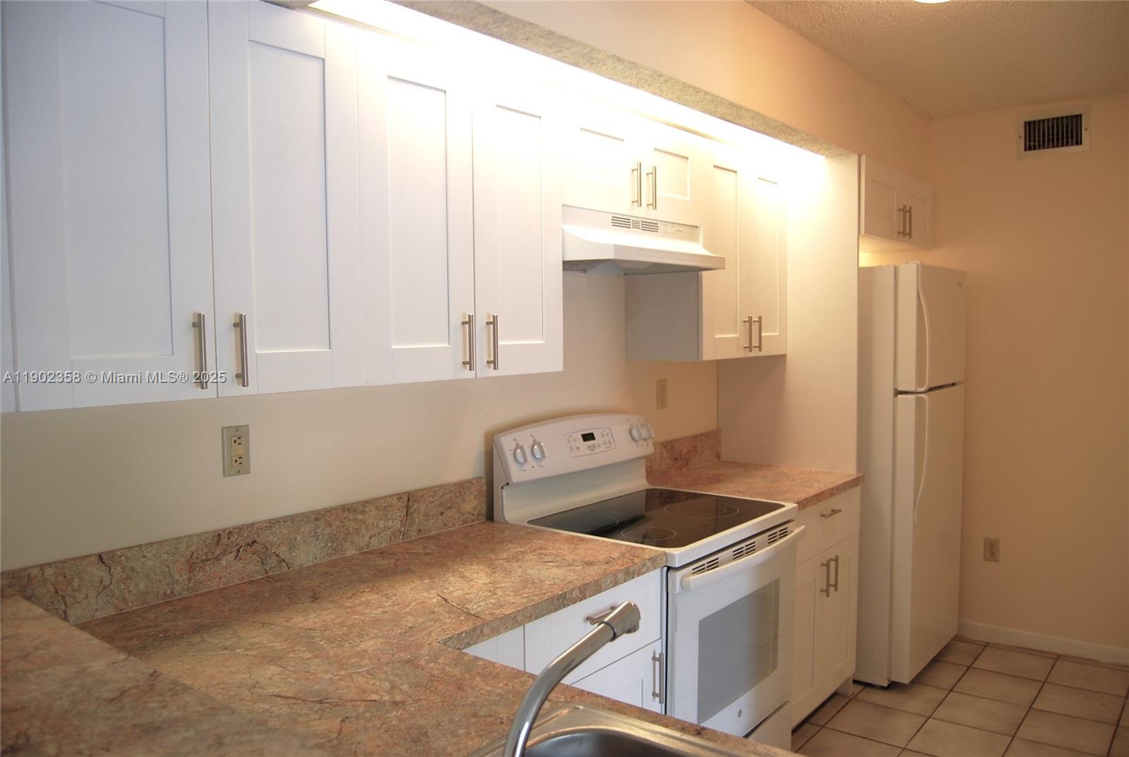 8540 Southwest 212th Street, Unit 203 Cutler Bay, FL 33189 - Photo 6 of 29 a kitchen that has a sink and a stove