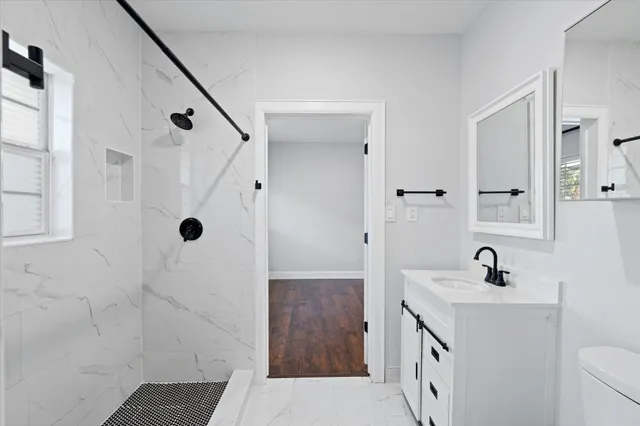 a bathroom with a sink a toilet and shower