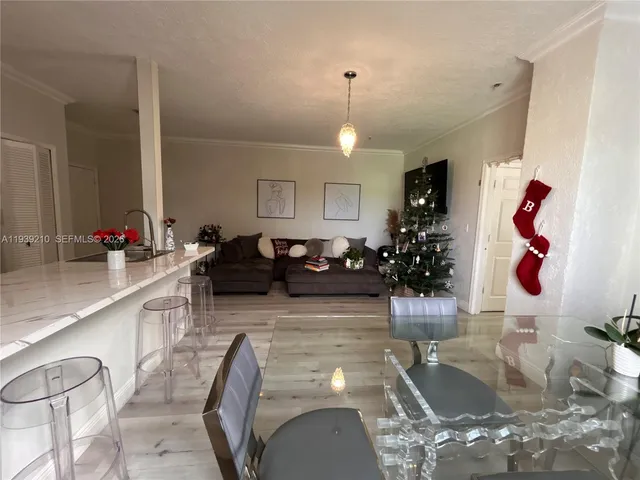 a living room with furniture kitchen view and a chandelier