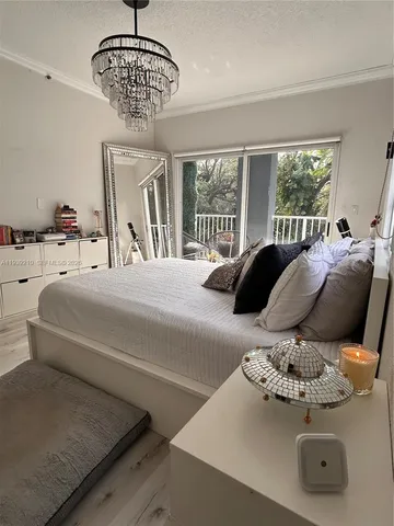 a bedroom with a large bed and a chandelier