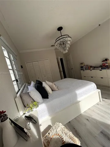 a bedroom with a bed and a chandelier