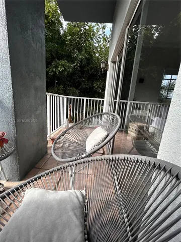 a balcony with wooden floor stairs and a potted plant