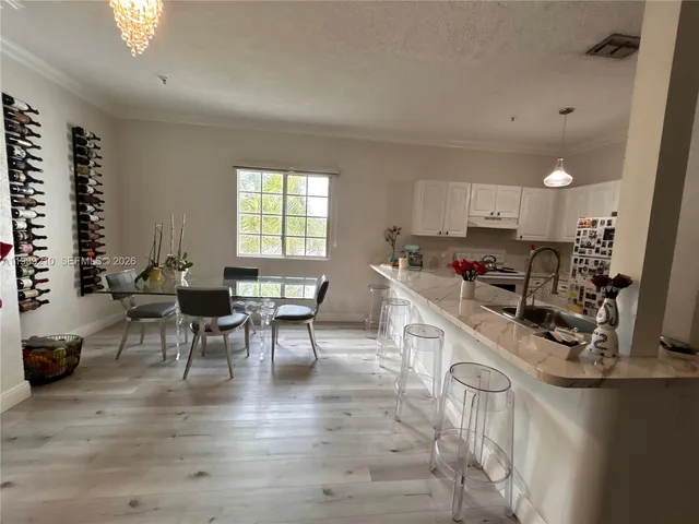 a kitchen with a sink a stove cabinets and wooden floor