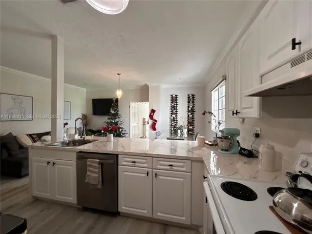 a kitchen with a sink a stove and cabinets