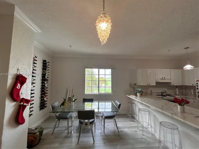 a kitchen that has a lot of cabinets furniture appliances and a window
