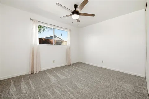 an empty room with closet and fan
