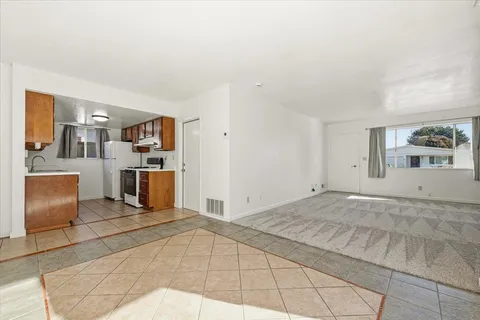 a view of kitchen with refrigerator cabinets and stove top oven