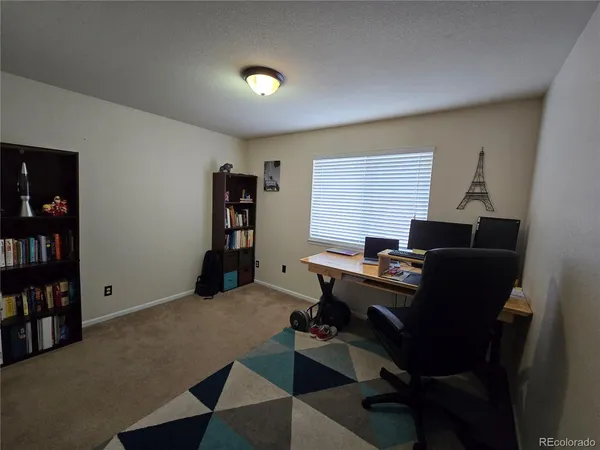 a view of a workspace with furniture and a bookshelf