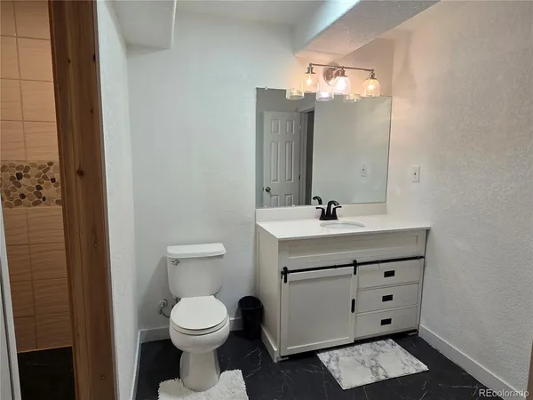a bathroom with a toilet a sink and mirror