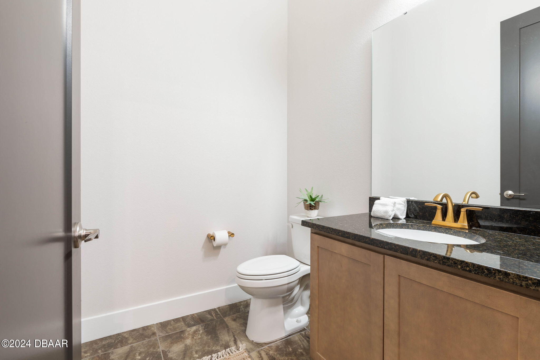 1405 Lilly Anne Circle Ormond Beach, FL 32174 - Photo 54 of 76 a bathroom with a granite countertop toilet and a sink
