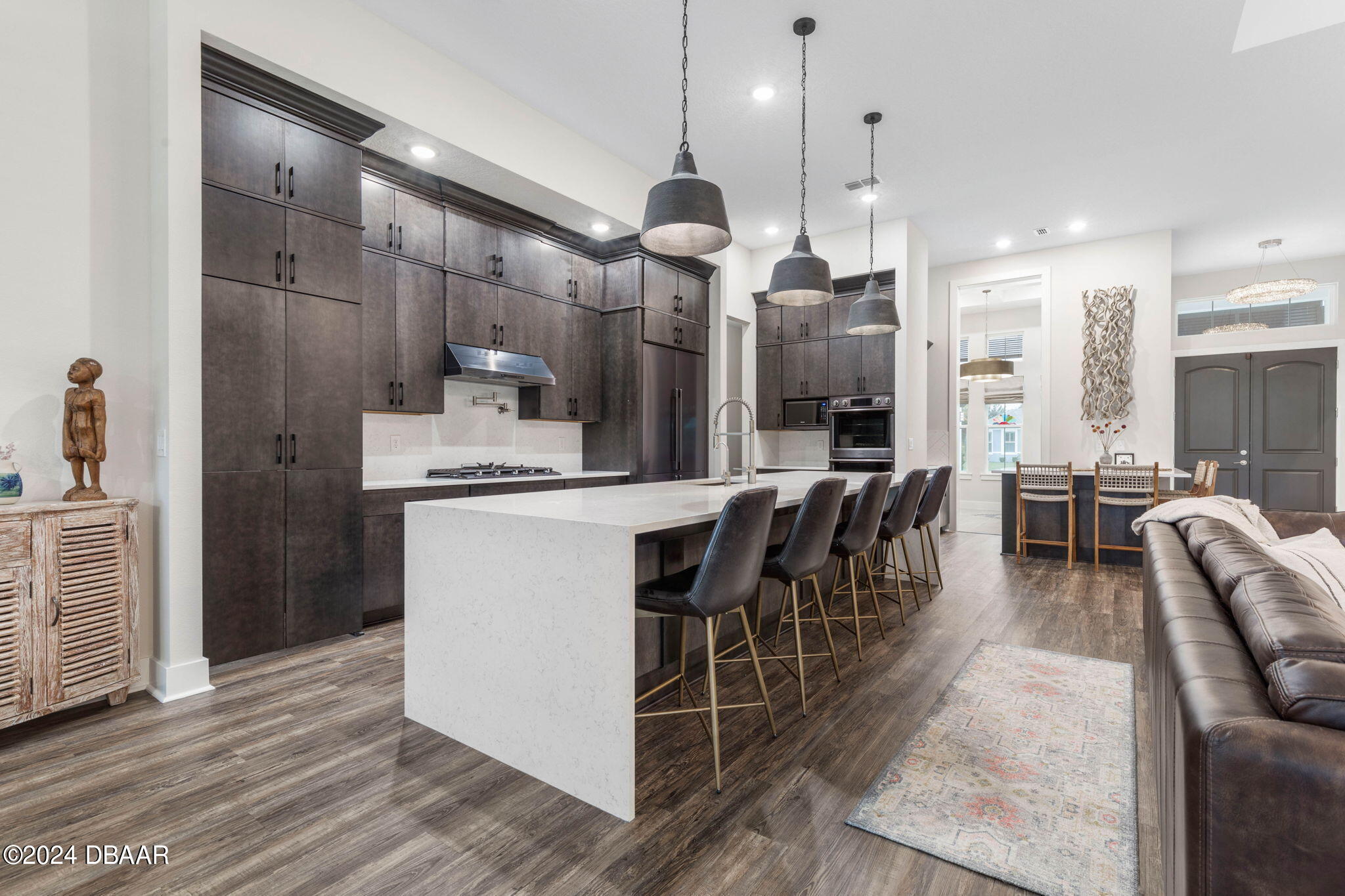 1405 Lilly Anne Circle Ormond Beach, FL 32174 - Photo 8 of 76 a kitchen with stainless steel appliances kitchen island granite countertop a stove a sink a refrigerator and a dining table with wooden floor