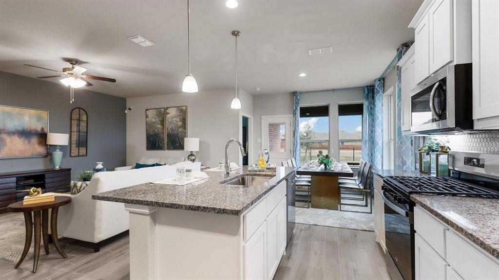 107 Goodnight Court Cleburne, TX 76033 - Photo 3 of 36 a kitchen with center island a sink appliances and a counter top space
