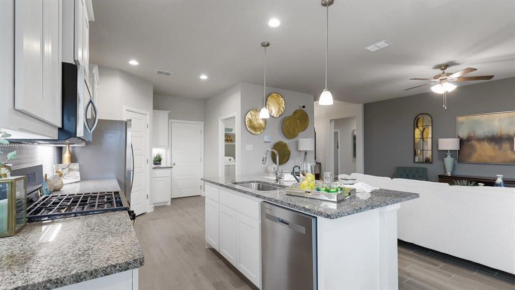 107 Goodnight Court Cleburne, TX 76033 - Photo 6 of 36 a kitchen with kitchen island granite countertop a sink a stove and a refrigerator