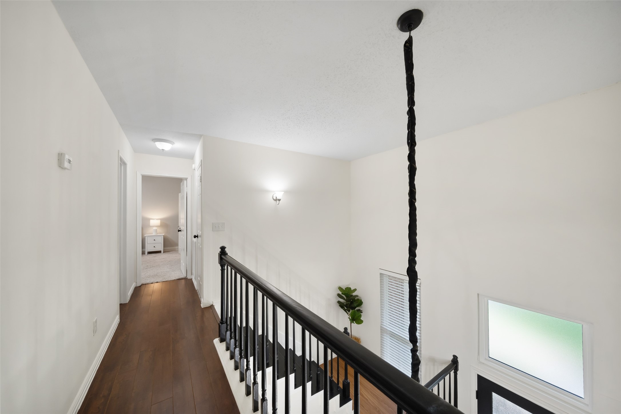 3 East Stony Bridge Circle Spring, TX 77381 - Photo 24 of 42 Viewed from above, this upper-level hallway features a modern light fixture and a black railing. A large window provides abundant natural light to the open space.