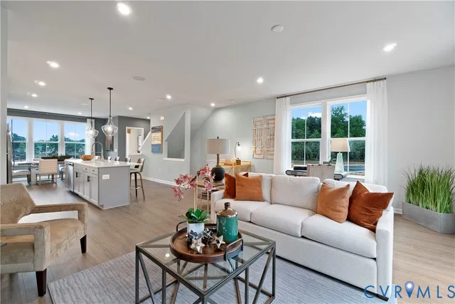 a living room with furniture kitchen and a large window