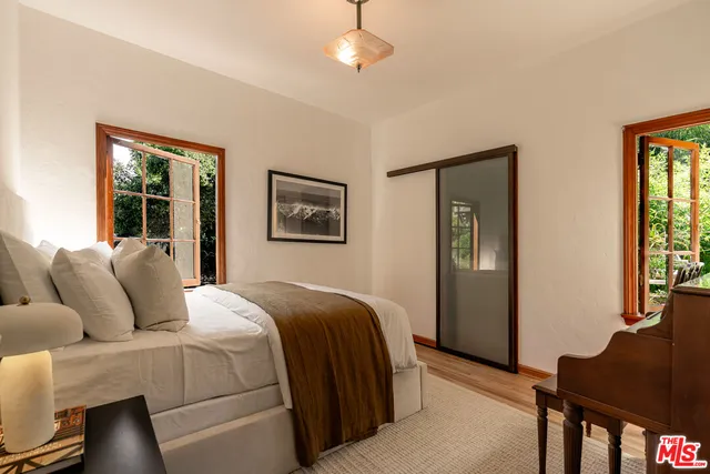 a bedroom with a bed and wooden floor