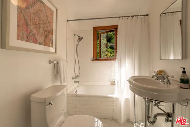a bathroom with a sink a bathtub and next to a window