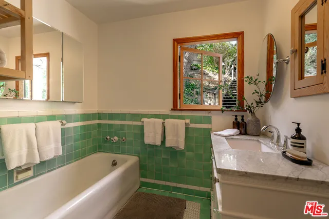 a bathroom with a granite countertop sink and a mirror
