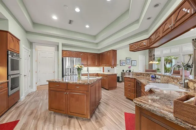 a bathroom with a granite countertop sink a mirror and bathtub