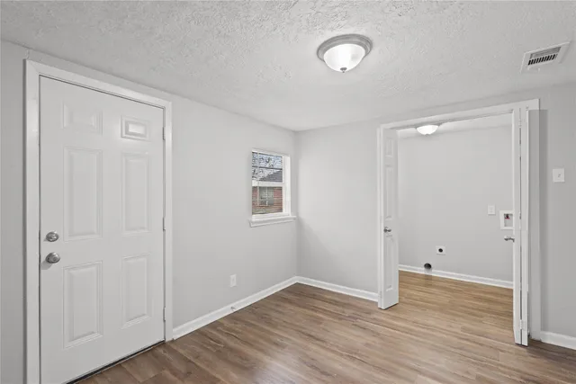 a view of an empty room with wooden floor