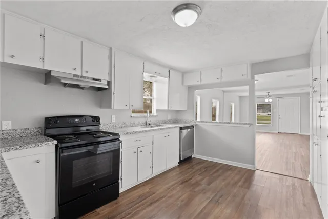 a kitchen with granite countertop white cabinets and appliances