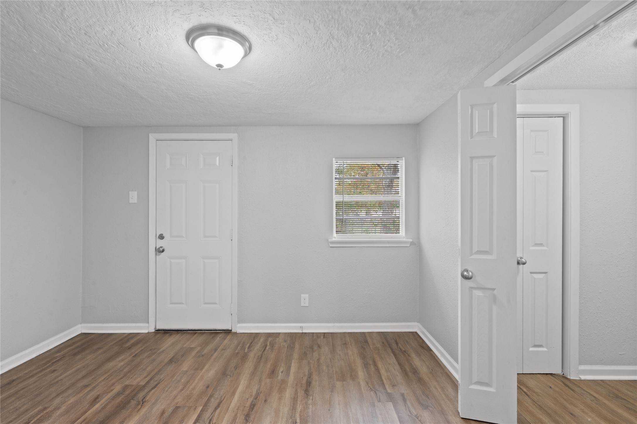 419 North Parrish Street Angleton, TX 77515 - Photo 6 of 25 an empty room with wooden floor and windows
