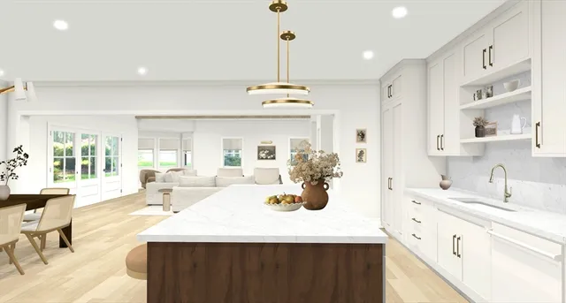 a large white kitchen with a sink dishwasher a stove and a dining table with wooden floor