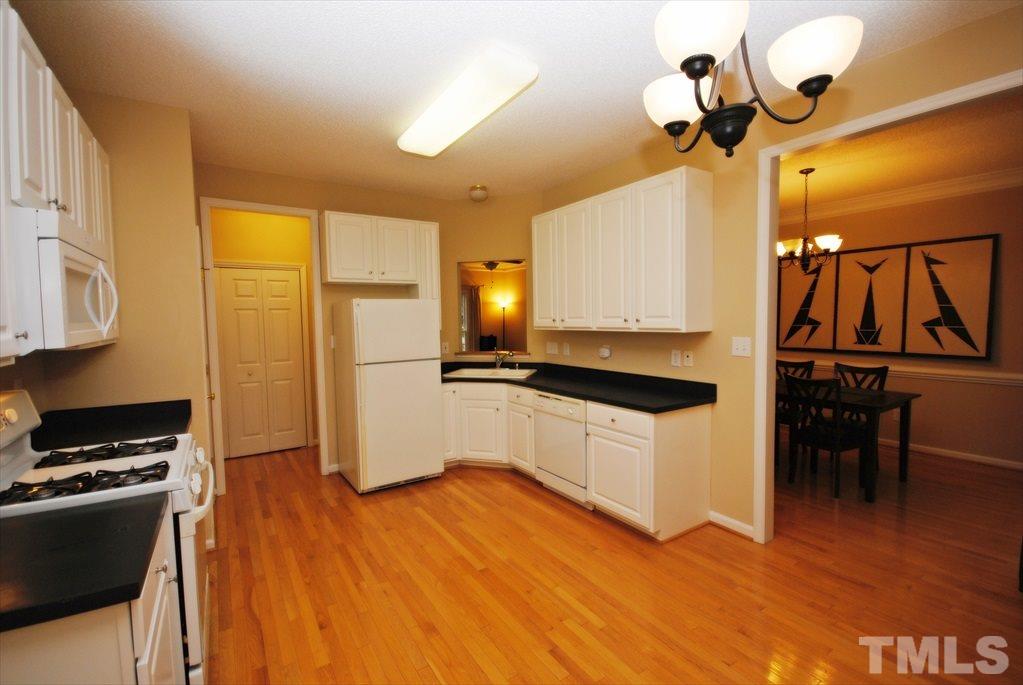 6915 Brigmore Court Raleigh, NC 27617 - Photo 11 of 25 a kitchen with stainless steel appliances granite countertop a stove and a refrigerator