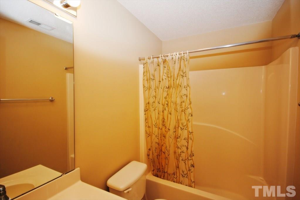 6915 Brigmore Court Raleigh, NC 27617 - Photo 16 of 25 a bathroom with a shower curtain and a toilet