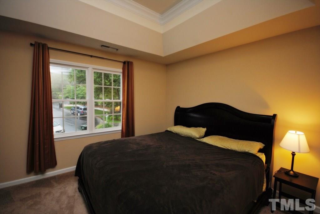 6915 Brigmore Court Raleigh, NC 27617 - Photo 19 of 25 a bedroom with a bed and a window