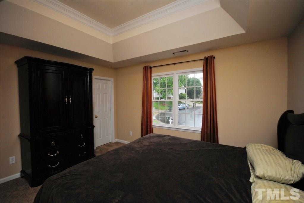 6915 Brigmore Court Raleigh, NC 27617 - Photo 20 of 25 a bedroom with a bed and a window