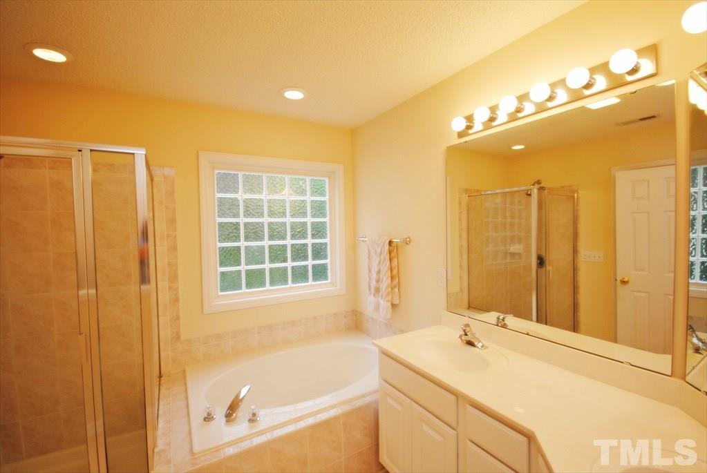 6915 Brigmore Court Raleigh, NC 27617 - Photo 21 of 25 a bathroom with a tub sink shower and mirror