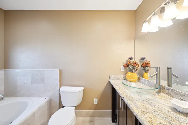 a bathroom with a granite countertop sink and a toilet