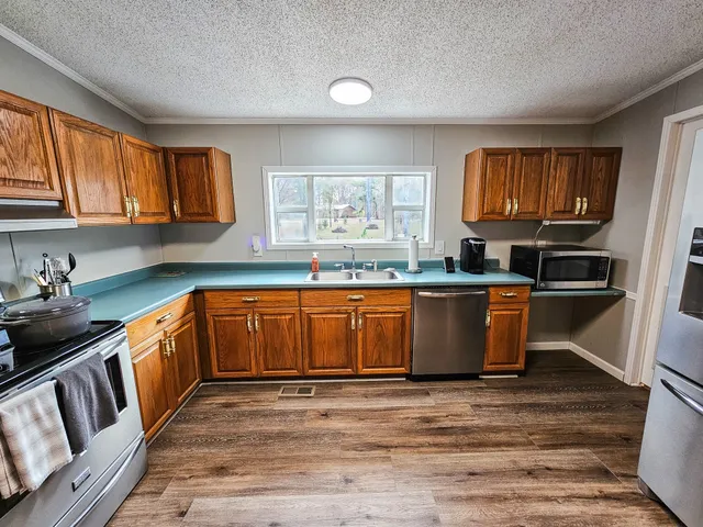 a kitchen with granite countertop a stove top oven sink and cabinets