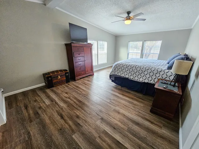 a bedroom with a bed and wooden floor