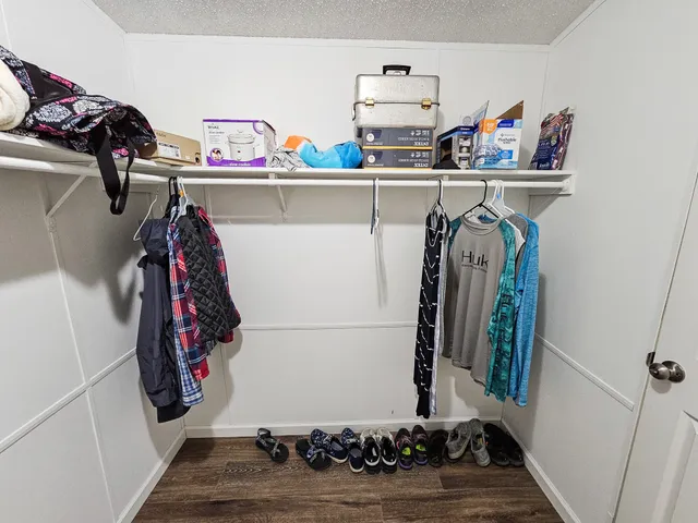 a view of walk in closet with clothes and shoes