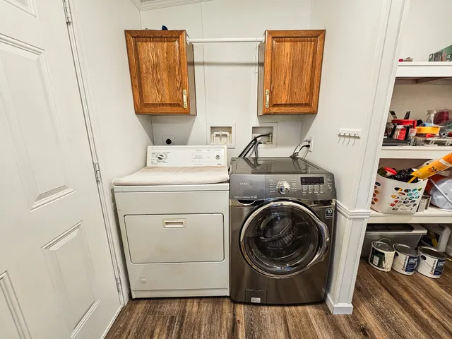 a utility room with dryer washer and a wooden floor