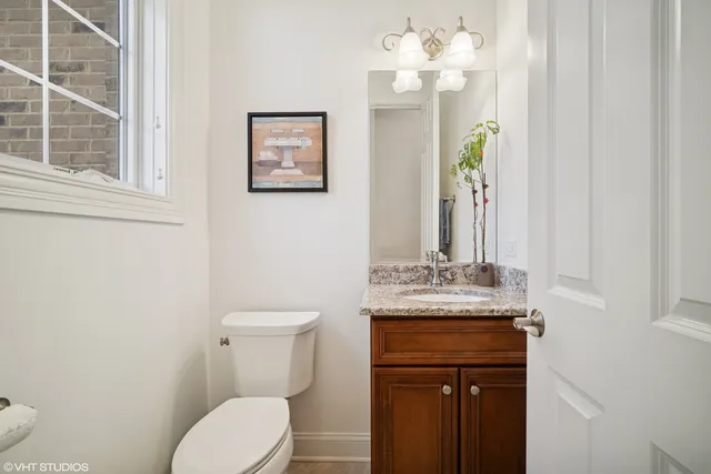 a bathroom with a granite countertop toilet sink and mirror