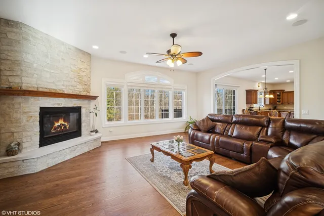 a living room with furniture a fireplace and a large window