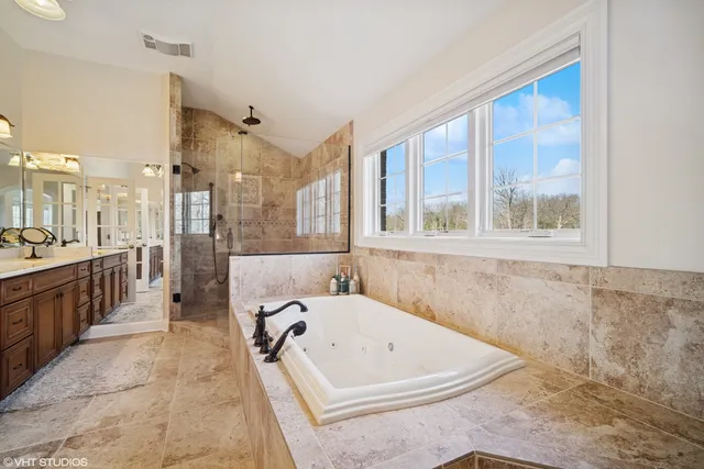 a bathroom with a tub a sink and a large window
