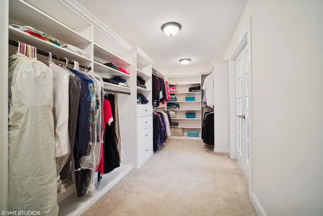 a view of walk in closet with clothes and shoes