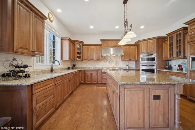 a kitchen with stainless steel appliances granite countertop a sink counter space cabinets and a large window